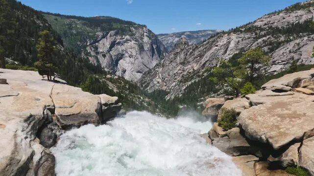 top of Nevada Fall featuring the Merced River, granite rock formations, mountain scenery, and wilderness landscapes in Yosemite National Park, California.