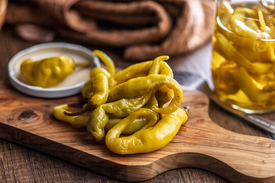 Pickled Banana Peppers On A Wooden Board .Rustic Preserved Snack