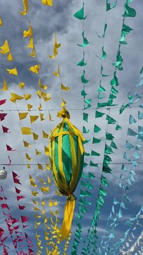 Muitos varais com bandeirolas coloridas e um bal&atilde;o balan&ccedil;ando com o vento, com c&eacute;u ao fundo.