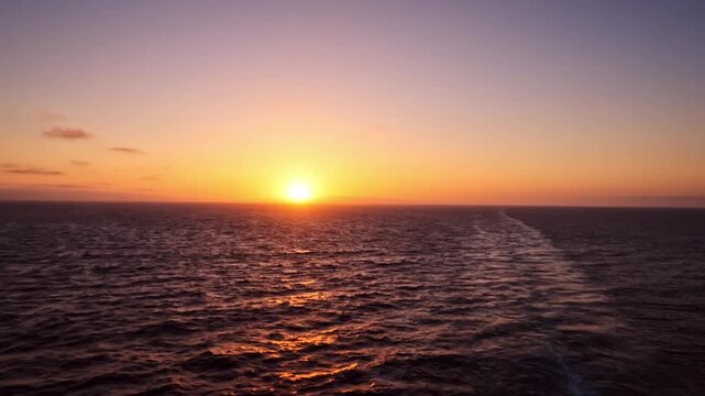 sailing at sunset on calm ocean waters with golden sky reflections and peaceful seascape views.