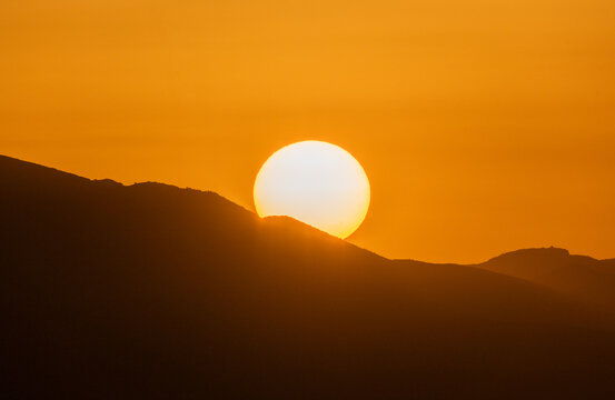 Extreme heatwave during El Nino phenomenon with sun setting over mountain range