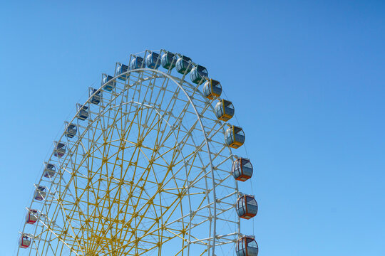 Colorful giant ferris wheel against a clear blue sky