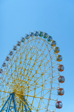 Colorful giant ferris wheel against a clear blue sky