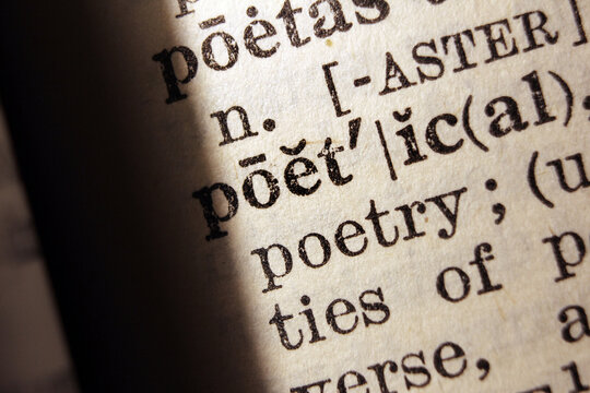 Words poetic and poetry on dictionary page, macro close up