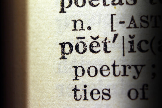 Word poetic on dictionary page, macro close up