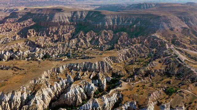 Drone view of Goreme Historical National Park, Cappadocia, Turkey. Pale hills, eroded formations and winding valleys stretch across the rugged landscape.