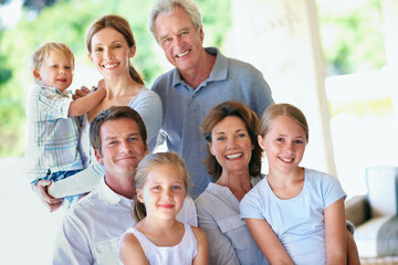 Obraz premium Portrait, big family and happy on patio for bonding, love and care with generations outdoor. Grandparents, parents and children with people on home porch, smile or relax together for trust and memory
