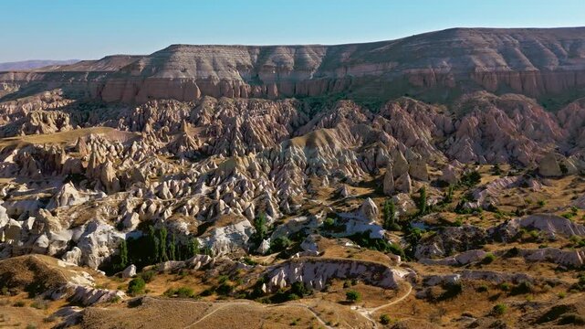 Aerial view of Goreme Historical National Park, Cappadocia, Turkey. Layered hills, eroded rock formations and open valleys show a scenic wide view.