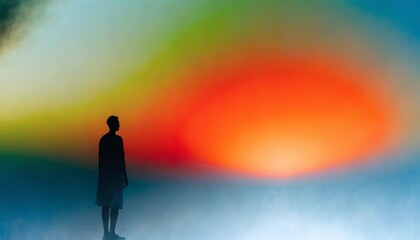 Obraz premium Small silhouetted person standing before a vivid abstract summer gradient of red, orange, yellow, green, and blue, evoking imagination, warmth, wonder, and an immersive colorful horizon