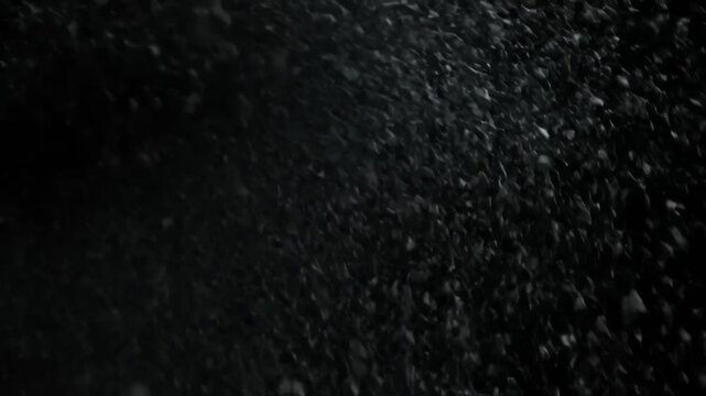Abstract monochrome image of falling debris with an obscured dark background