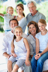 Obraz premium Portrait, big family and happy generations outdoor for bonding, love and care on patio. Grandparents, parents and children with people on porch, smile and relax together for trust and memory