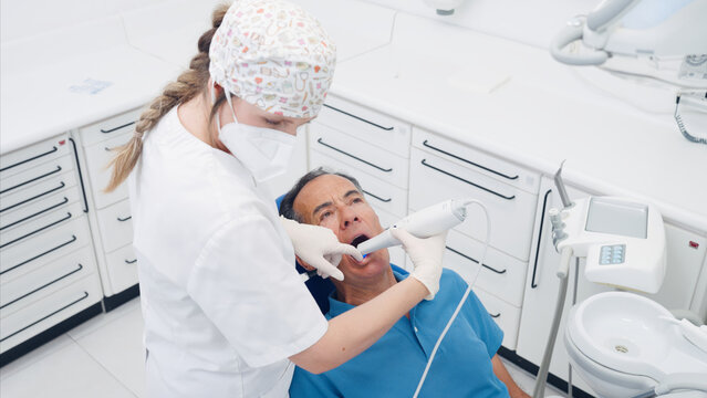 Dentist performing digital scanning on a patient's teeth in a modern dental clinic, demonstrating advanced oral care technology