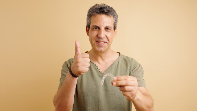 Happy man endorsing new clear aligner for teeth straightening, showing satisfaction with modern dental treatment