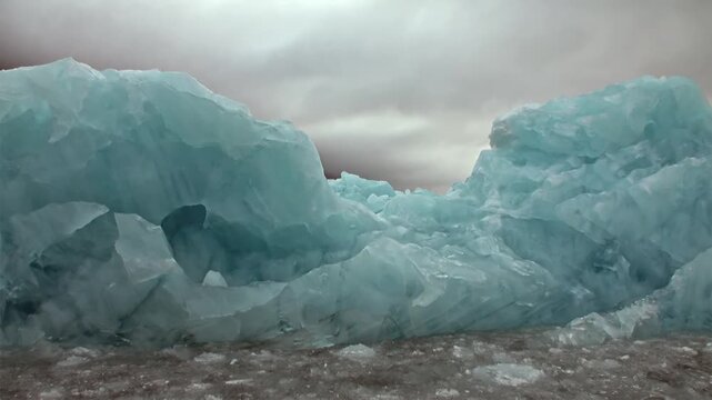 Glimpse stunning blue glacial ice formations as they elegantly float through cool Arctic waters of Svalbard, Norway. Captivating summer spectacle showcasing raw, frozen grandeur of far North.