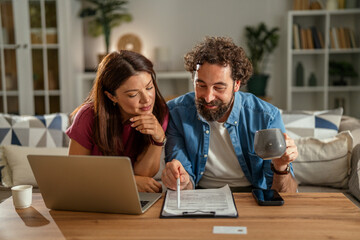Couple planning home finances online with documents