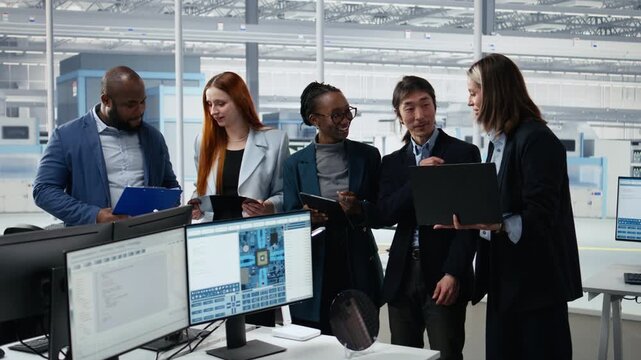 Portrait of smiling diverse engineering team optimizing PCB production in factory office, cheerful colleagues using devices.
