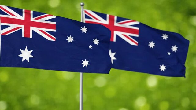Two australian flags waving against a blurred green background