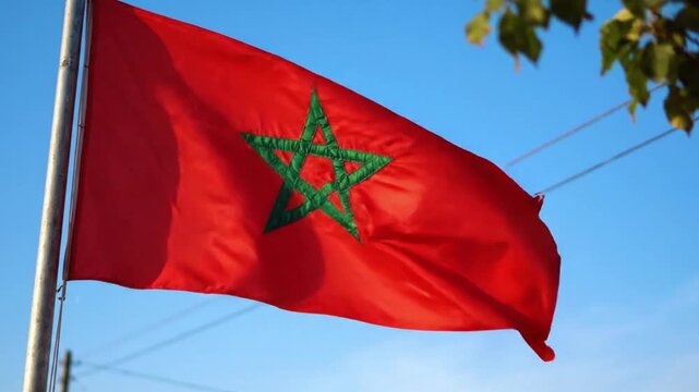 The national flag of morocco waving against a clear blue sky