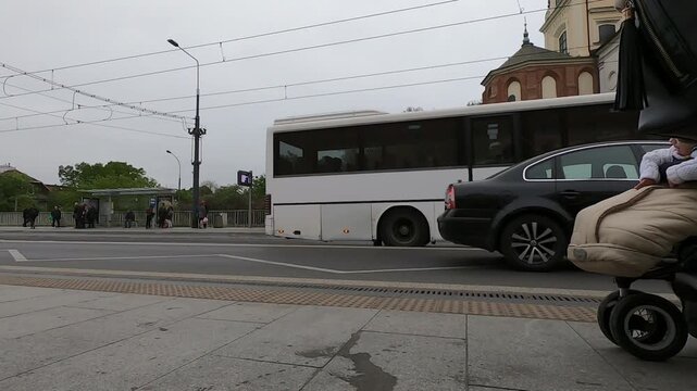 People boarding on buses / trams at the Old Town station (Stare Miasto) in aleja Solidarnosci street. People get in bus and tram cars. Traffic Rush Hour.