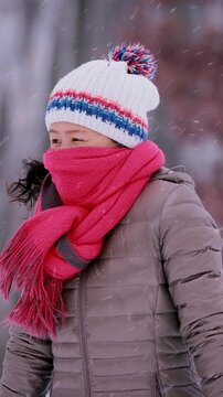 Asian woman freezing on a cold winter day in Minnesota. Vertical video.