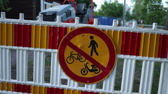 warning sign on a barrier prohibiting access for pedestrians bicycles and mopeds highlighting restricted entry traffic regulations and public safety