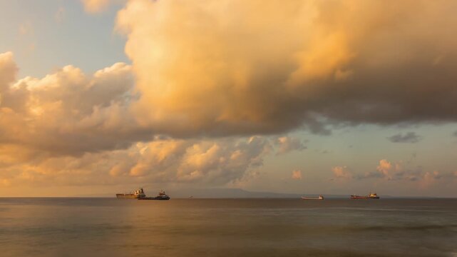 Time lapse of the beautiful morning clouds over the ocean in Bali Indonesia at sunrise. Cardgo ships can be seen in the distance.