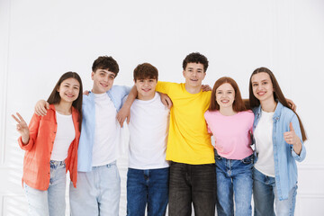Obraz premium Portrait of happy teenagers near white wall indoors