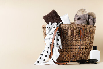 Obraz premium Bag with beach accessories on beige background. Space for text