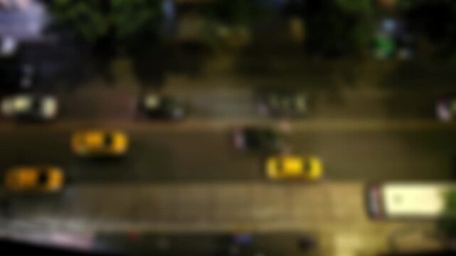 Vista a&eacute;rea desenfocada del tr&aacute;fico nocturno en una avenida de la ciudad con luces en movimiento