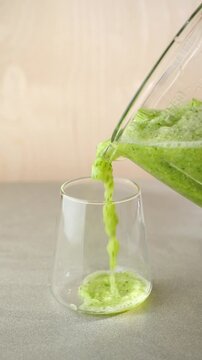 pour a healthy green smoothie into a glass