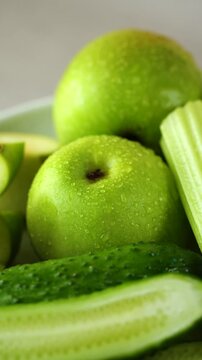 close-up of a green apple, cucumbers and celery, ingredients for a green smoothie