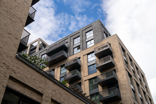 Modern Urban Apartment Building Exterior With Balconies Against Cloudy Sky