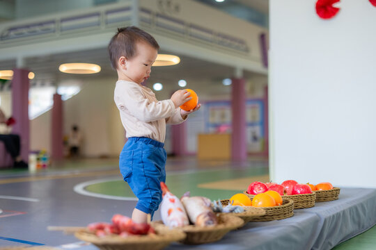 Little boy choosing plastic fruit