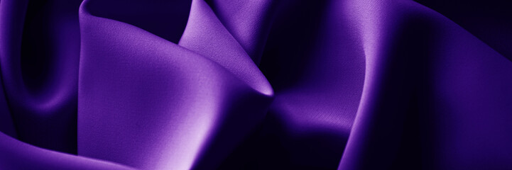 Black dark deep blue violet purple indigo silk satin. Smooth shiny silky fabric material. Elegant beautiful background. Soft folds drapery. Bright glow light. Design. Wide banner. Panoramic.