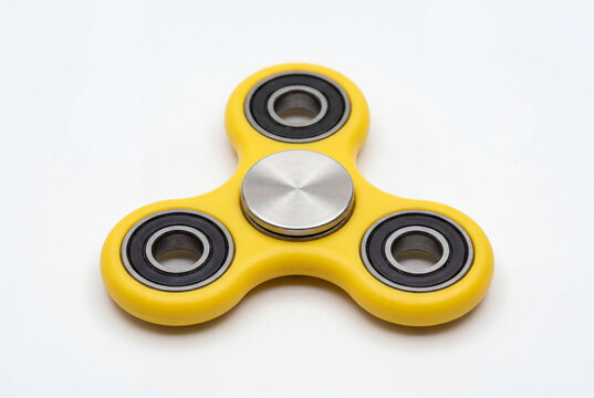 Yellow fidget spinner on a clean white background a popular toy