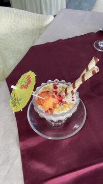 Delicious Falooda Dessert with Wafer Sticks and Cocktail Umbrella Garnish - 4K Vertical Video Footage