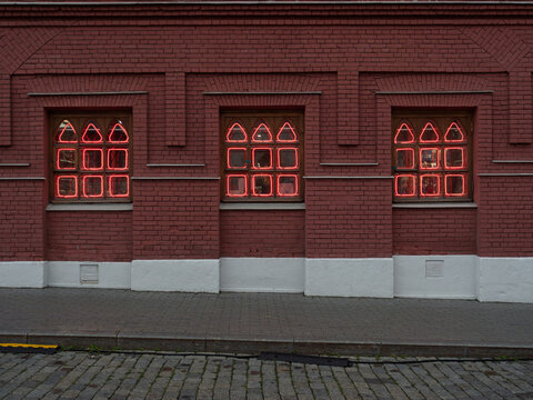 Illuminated Red Neon Windows on Brick Wall