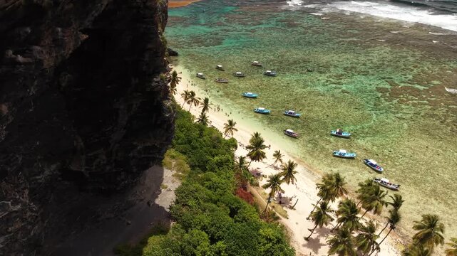 Drone aerial showing transparent waters, visible coral formations and tropical scenery at Fronton Beach.