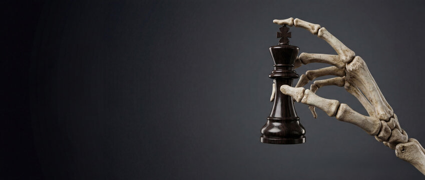 Human skeleton hand holding black chess king piece against dark background banner