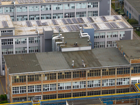 Aerial view of industrial facility with solar panels on the roof and metal ventilation pipes in Breclav, South Moravian Region, Czechia.