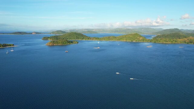 Aerial drone footage of Gili Goleng island bay, in West Sekotong, Lombok island, Indonesia, with Gili Asahan touristic paradise island aside, at golden sunset, with boats, Gili Gede behind