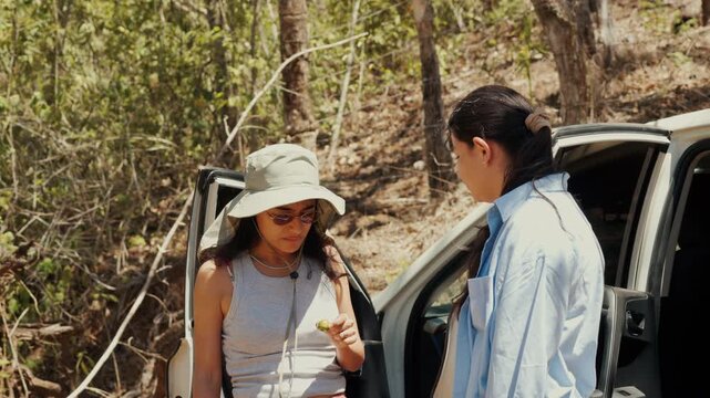 Female botanists examining wild fruit during field research