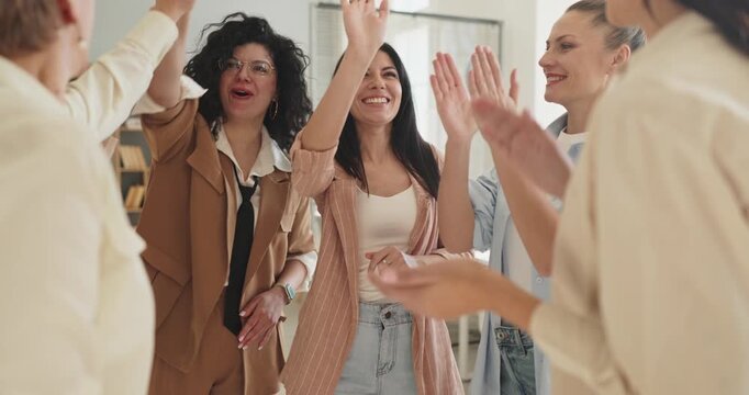 Women business team applause during training coaching. In a modern office circle, colleagues smile and clap to honor shared achievement. Team bonding. Celebrating teamwork motivation and success.