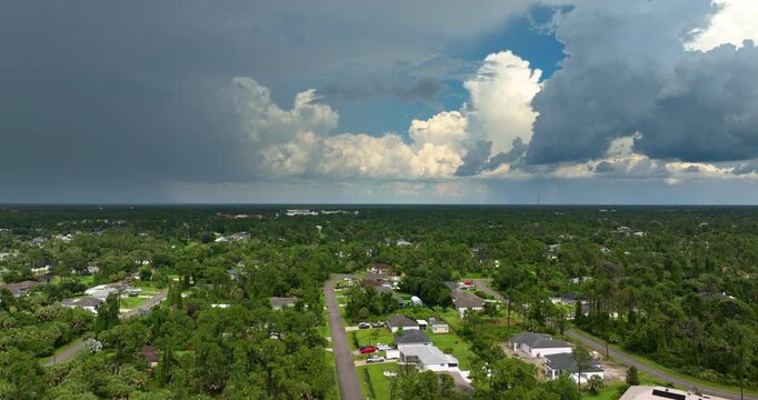 Rainstorm shower over Florida rural town in humid summer season. Rain water pouring down from stormy clouds.