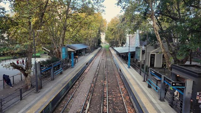 Railway tracks and platforms of historic Coghlan station from English style iron pedestrian bridge in autumn sunset Buenos Aires Argentina travel