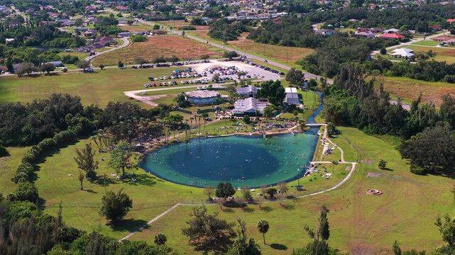 Natural sinkhole filled with clear blue mineral water, used for swimming and spa-like relaxation, symbolizing health, healing and mindful travel in the southern USA.