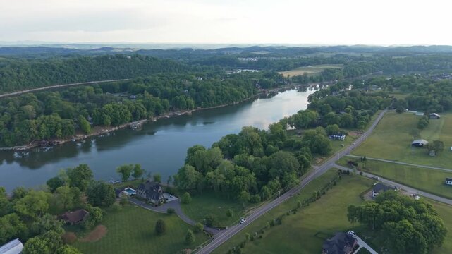 Aerial footage captures a tranquil river flowing through vibrant greenery and rolling hills in Johnson City, Tennessee, highlighting the harmony between nature and the serene waterway in the landscape