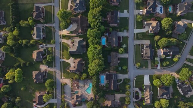 Aerial perspective of suburban neighborhood in Johnson City Tennessee featuring various residential homes lush green lawns swimming pools with tree-lined streets organized layouts evident in scene
