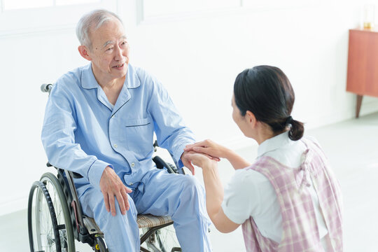 車椅子に乗った高齢者をサポートする介護士
