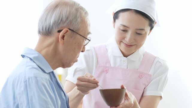 高齢者の食事の介助をする介護士